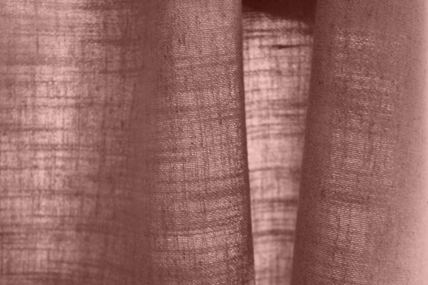 Detailfoto van de stofdetails van de roze gordijnen uit de Elegance collectie, kleur JC2457 een effen gordijnstof met een zachte structuur en een warme, subtiele roze tint voor een elegante uitstraling.