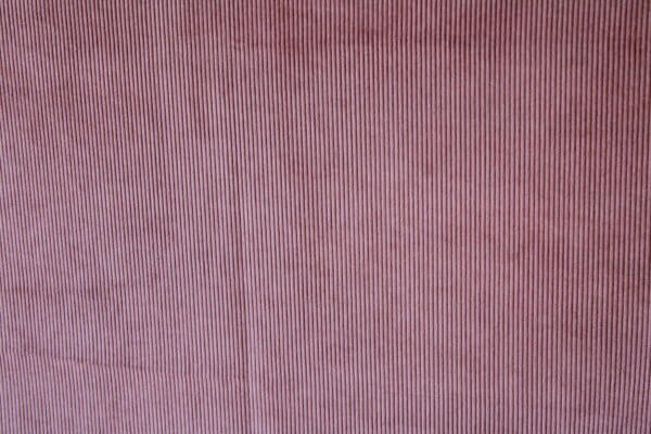 Detail van het donker roze Corduroy gordijn, JC2403 van okika. Toont de fijne ribbels in de luxe stof.