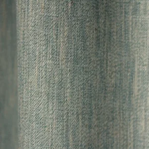 Detailopname van het weefpatroon van de blauwe inbetween gordijnen met natuurlijke textuur.