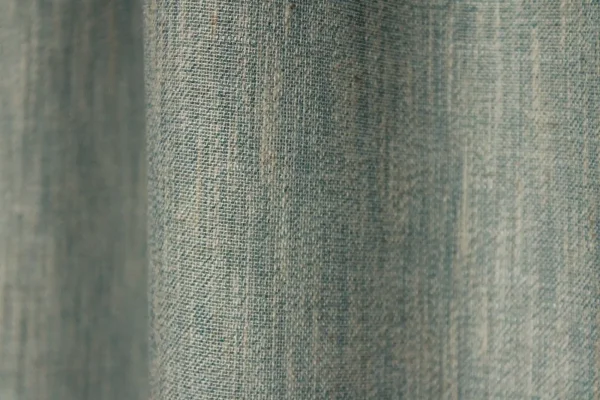 Detailopname van het weefpatroon van de blauwe inbetween gordijnen met natuurlijke textuur.
