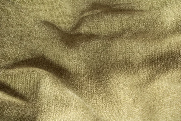 Detail van pistachekleurige chenille vouwgordijnen met zachte structuur