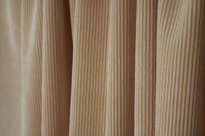 Crèmekleurig Corduroy gordijn, jc2410 van okika. Vloeiend vallend, perfect voor een minimalistisch en licht interieur.