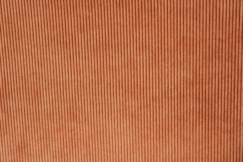 Corduroy gordijnstof in warme oranje tint, model JC2408 van OKIKA, met kenmerkende ribstructuur en duurzame, zachte uitstraling