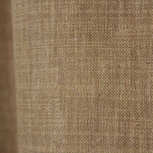 Close‑up van de honingkleurige inbetween stof met zachte weving en subtiel gemeleerd effect.