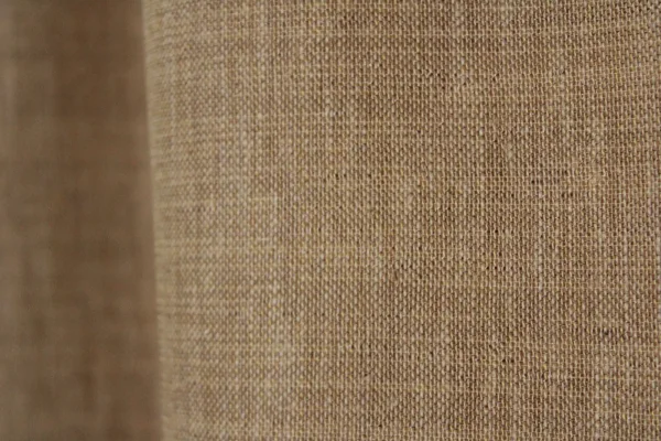 Close‑up van de honingkleurige inbetween stof met zachte weving en subtiel gemeleerd effect.