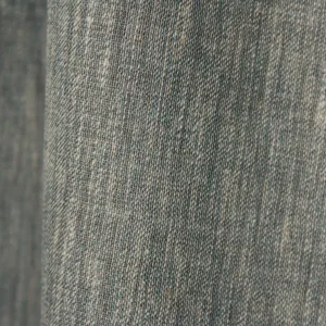 Close‑up van de gemêleerde indigo blauwe inbetween stof met fijne weving en subtiel lichtspel.