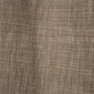 Close-up van de soft taupe inbetween stof met subtiele weving en natuurlijke lichtdoorlaat.
