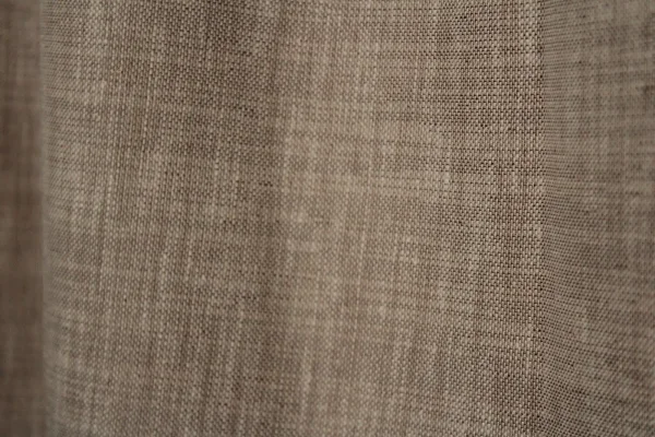 Close-up van de soft taupe inbetween stof met subtiele weving en natuurlijke lichtdoorlaat.