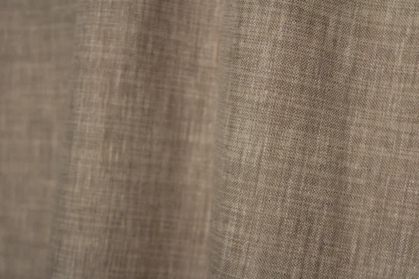 Detailopname van het gemeleerde weefpatroon van de soft taupe inbetween gordijnen met een elegante structuur.