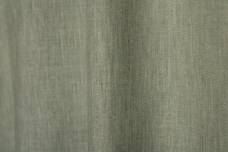 : Sfeerfoto van turquoise inbetween gordijnen uit de Zenweave collectie JC2484, lichtdoorlatend en stijlvol voor een frisse en moderne uitstraling