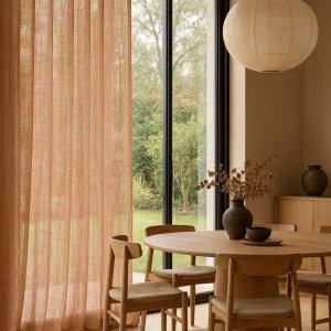 Inbetween gordijn Zen Weave in terra kleur sfeerimpressie in moderne woonkamer met warme lichtinval en natuurlijke materialen