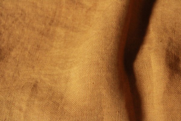 Detail van linnen vouwgordijn Elite in okergeel – close-up van het geweven patroon van stof JC2491.