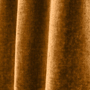 Close-up van een vintage velours gordijn in okerkleur, model BB2412 'Okika'. De luxe velourstructuur en warme, diepe tint zorgen voor een elegante en sfeervolle uitstraling.