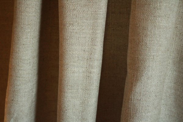 linnen gordijnstof in naturel zandkleur van Okika bb2510, met een natuurlijke textuur die een lichte en frisse uitstraling aan elke ruimte geeft.
