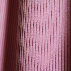 Detail van ribstof roze gordijnen van Okika, zachte en elegante stofstructuur.