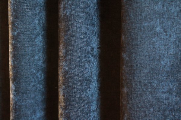 Velours gordijnen van okika in het donker blauw, chenille achtige structuur met in de stof een krijt effect verwerkt voor een heel uniek effect. opvallende velours gordijnen waarin veel gebeurt.