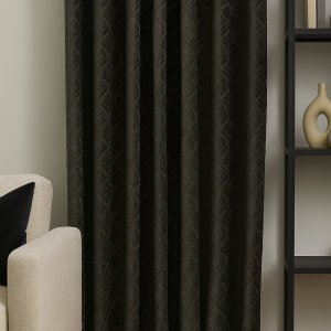 Sfeerimpressie van zwarte gordijnen met retro bloemenpatroon in een interieur met vintage accenten.