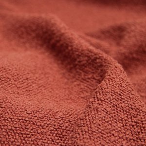 Close-up van terrakleurige bouclé gordijnstof (BB2313) met zichtbare grove lusstructuur en zachte, warme textuur.