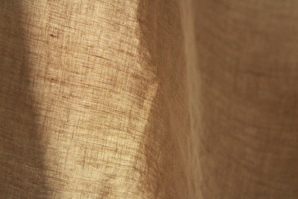 Linnen gordijnen van de elite collectie in het taupe met detail van stofstructuur in close-up