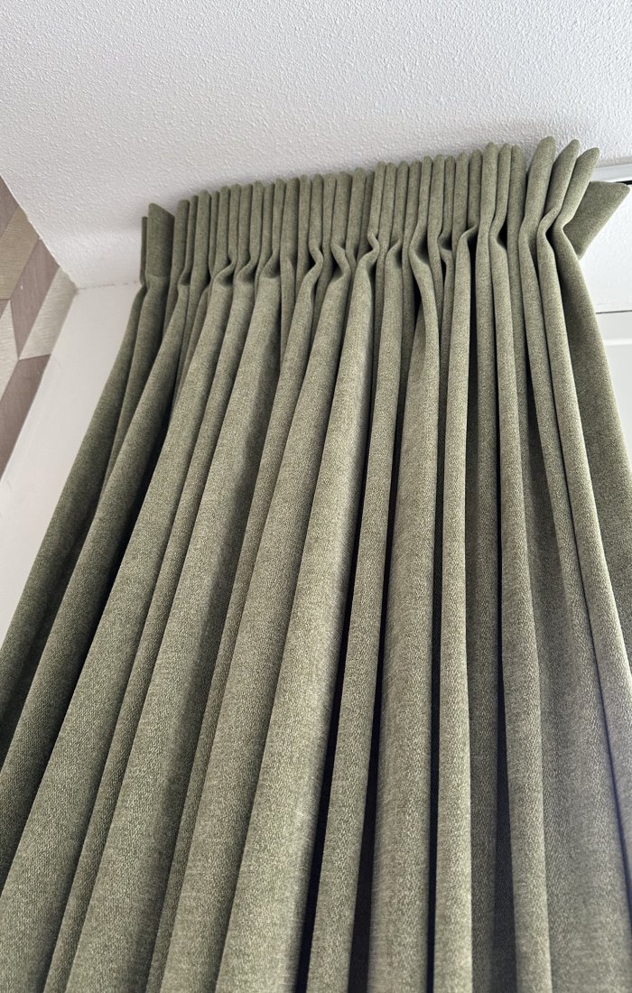 Sfeervolle slaapkamer met pistachekleurige chenille gordijnen die het raam aankleden. gordijn met enkele plooi van een recent project