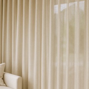 Champagnekleurige linnen-lurex gordijnen, sfeervol toegepast in een licht interieur met een elegante en subtiele glans.