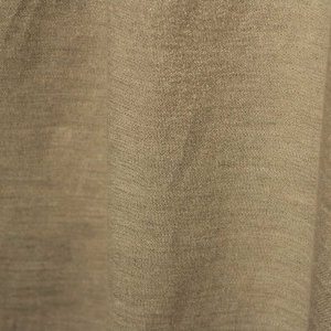 Stofpatroon van de champagne kleurige linnen gordijnen met lurex uit de Okika collectie, recht geplooid met zicht op de natuurlijke structuur en verfijnde metallic glans.