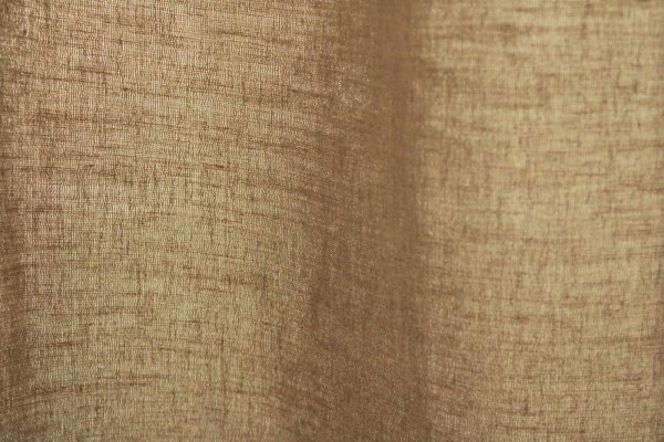 Stofstructuur van d echampagne kleurige linnen gordijnen met lurex uit de Okika collectie, met zicht op de fijne linnenweving en subtiele glinstering van het metallic draad