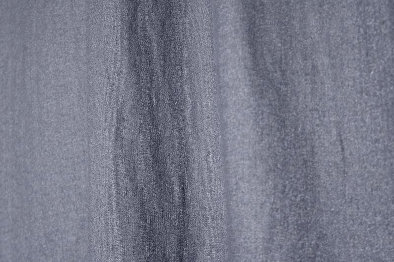 Sfeerfoto van de donkerblauwe linnen gordijnen met lurex uit de Okika collectie, natuurlijk hangend met een subtiele glinstering en stijlvolle lichtinval.