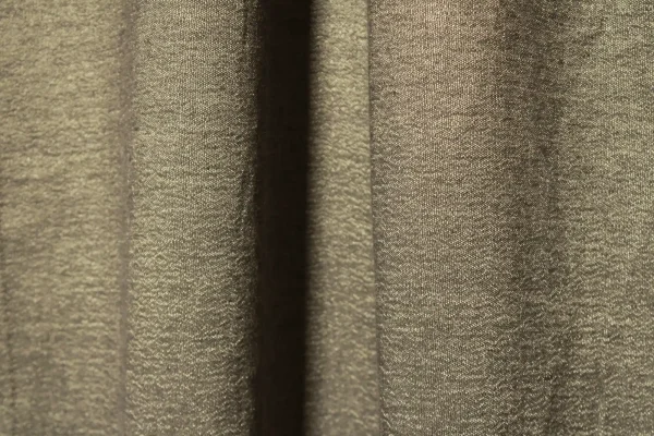 Sfeerfoto van te taupe kleurige linnen gordijnen met lurex uit de Okika collectie, elegant hangend met een natuurlijke uitstraling en subtiele metallic glans.