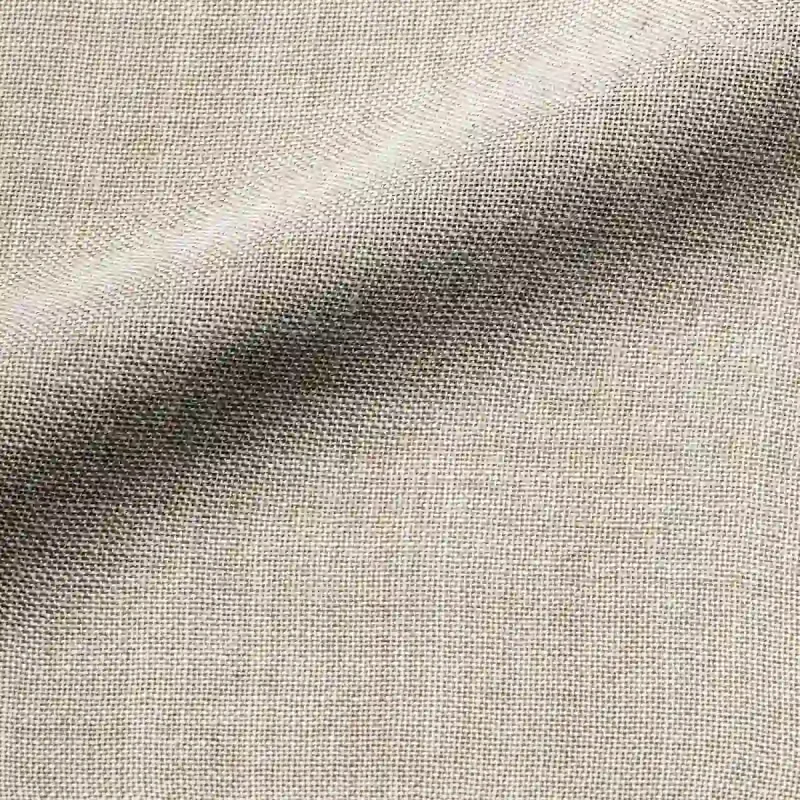 Close-up van het stofpatroon van beige Norena vouwgordijnen, kleur REY2580 een effen gordijnstof met subtiele structuur in een zachte, natuurlijke beige tint.
