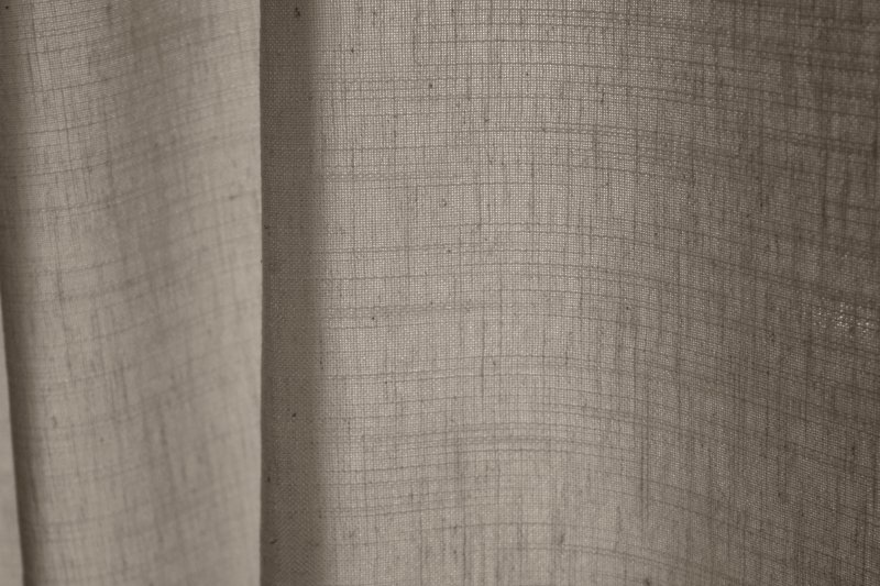 Detailfoto van offwhite gordijnen uit de Elegance collectie, model JC2545 Okika. De stofstructuur toont een fijn geweven patroon met een semi lichtdoorlatende eigenschap. De stof is kleurvast en slijtvast, ideaal voor langdurig gebruik.