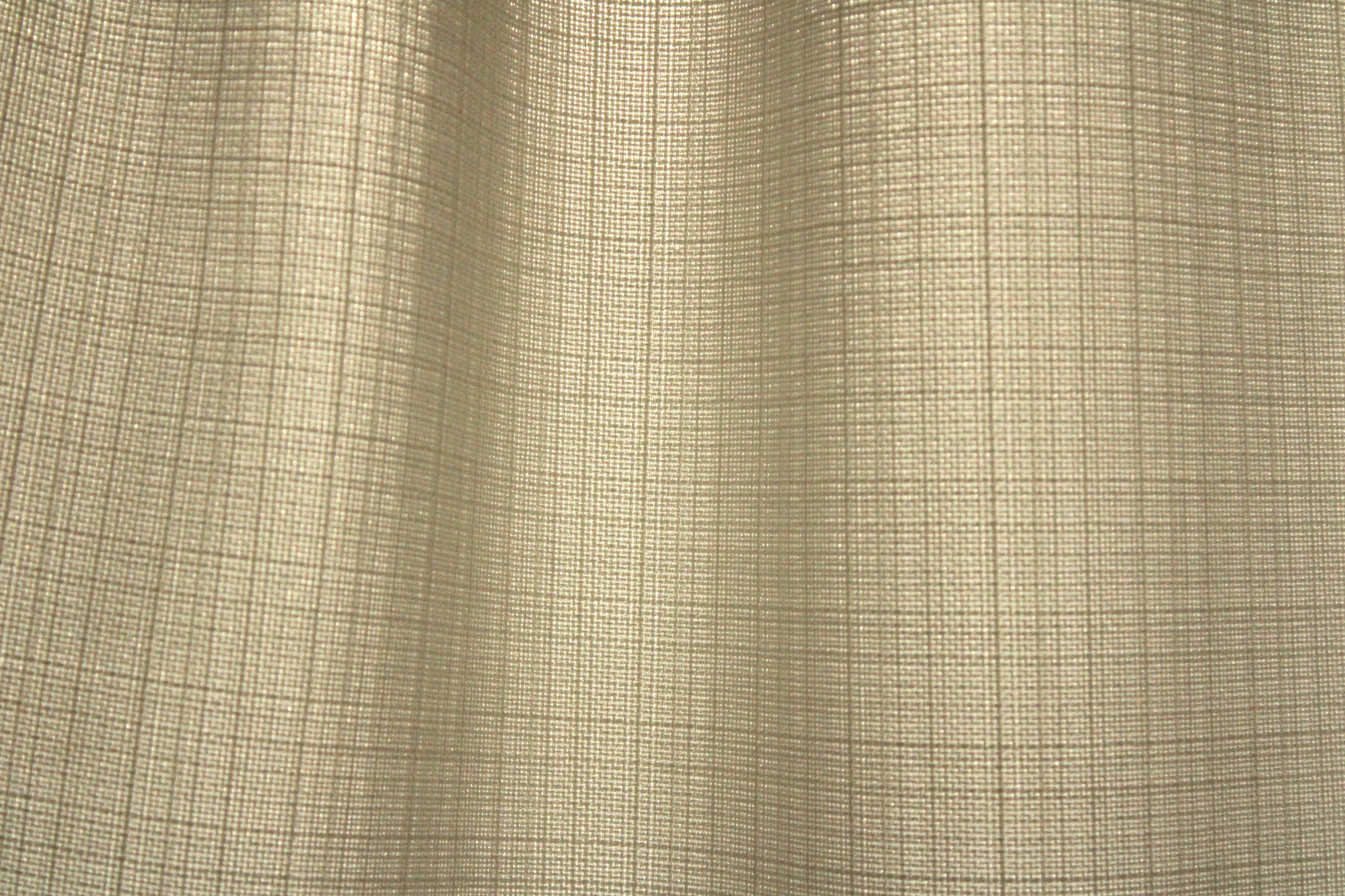 Close-up van de stofstructuur van offwhite gordijnen uit de Florain collectie (JC2511) van Okika, filteren het daglicht op subtiele wijze