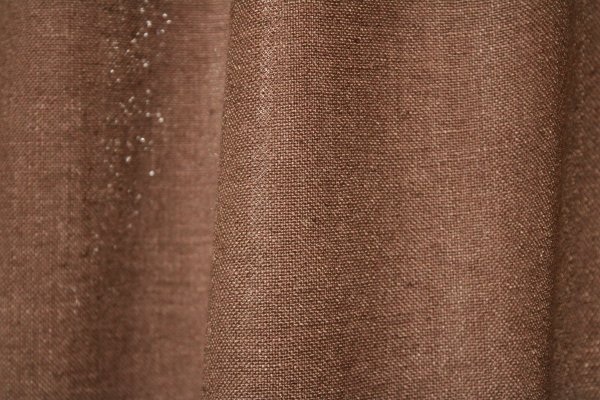 Detailfoto van de stofstructuur van warm taupe Elegance gordijnen uit de JC2550 collectie. Een volle, effen gordijnstof met een rijke en warme uitstraling.