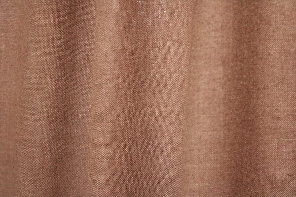 Sfeerfoto van het stofpatroon van warm taupe Elegance gordijnen uit de JC2550 collectie effen gordijnstof met een volle valling en warme, neutrale tint.