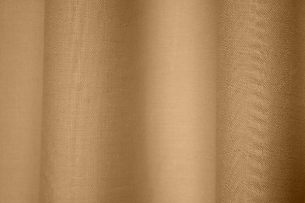 Stofdetails van beige gordijnen met linnen look uit de Saphira collectie van Okika, met zicht op de volle weving en natuurlijke structuur.
