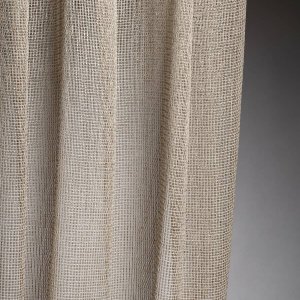 Linea-collectie van Okika met hele luxe beige inbetween gordijnen, met een metallic draad