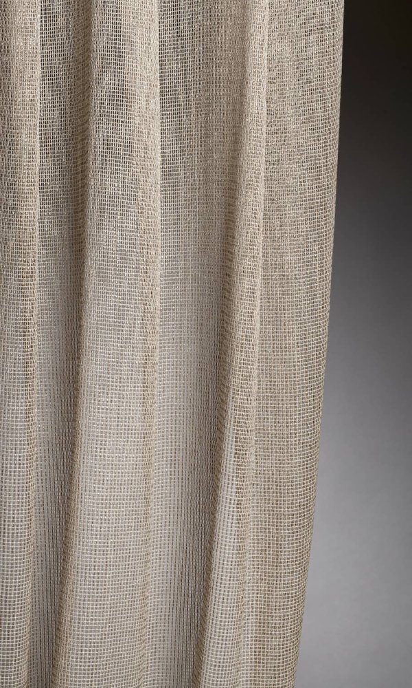 Linea-collectie van Okika met hele luxe beige inbetween gordijnen, met een metallic draad