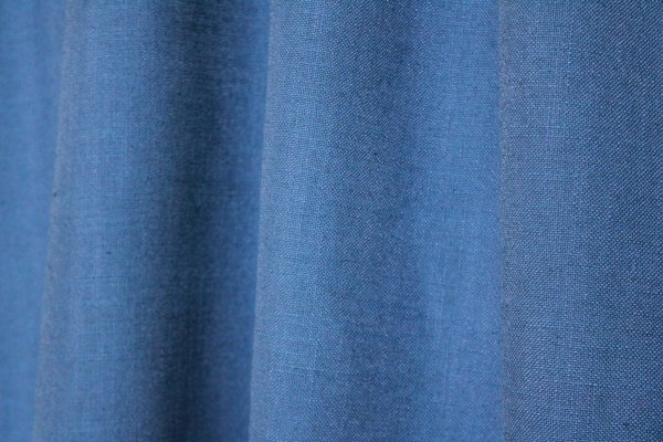 sfeerfoto van blauwe gordijnen uit de Elegance collectie, model JC2556 Okika. De semi lichtdoorlatende stof is kleurvast en slijtvast.