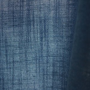 Close-up van de stofstructuur van blauwe Elegance gordijnen uit de JC2556 collectie een effen gordijnstof met een volle textuur en diepe, elegante blauwtint.