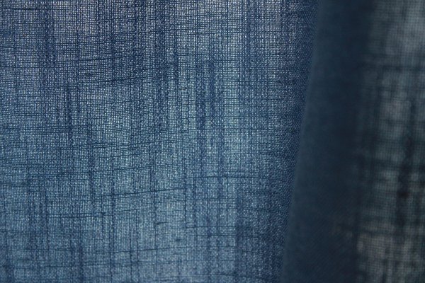 Close-up van de stofstructuur van blauwe Elegance gordijnen uit de JC2556 collectie een effen gordijnstof met een volle textuur en diepe, elegante blauwtint.