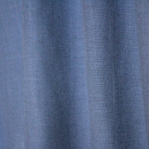 Sfeerfoto van denimblauwe gordijnen uit de Elegance collectie, model JC2557 Okika. De gordijnen hebben een semi lichtdoorlatende, fijn geweven stof die zacht licht doorlaat. Kleurvast en slijtvast.