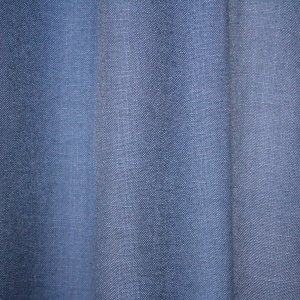 detail van de denim blauwe gordijnstof Elegance collectie JC2557 Okika met een fijnn geweven patroon. De semi lichtdoorlatende stof zorgt voor zachte lichtfiltering, kleurvastheid en slijtvastheid