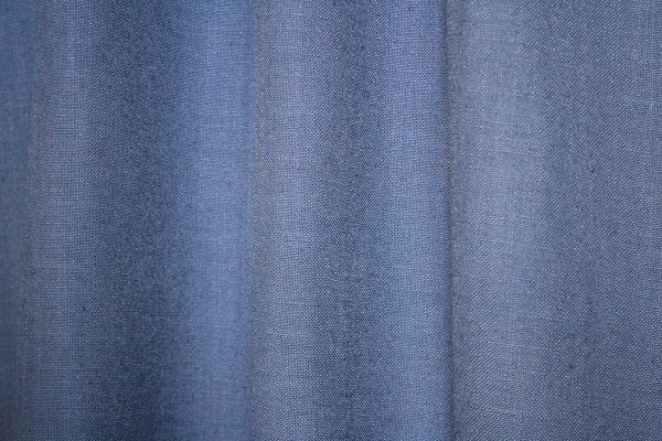 detail van de denim blauwe gordijnstof Elegance collectie JC2557 Okika met een fijnn geweven patroon. De semi lichtdoorlatende stof zorgt voor zachte lichtfiltering, kleurvastheid en slijtvastheid