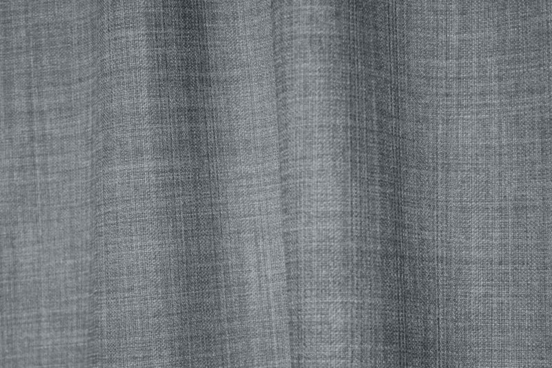 detailfoto van de stof van grijsblauwe gordijnen uit de Florain collectie (JC2521) van Okika, met een subtiele weefstructuur.