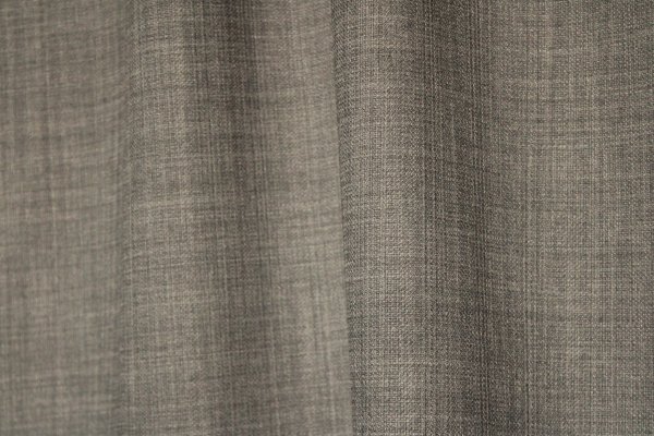 Close-up van de grijsblauwe gordijnstof uit de Florain collectie (JC2521) van Okika, met suvtiel gemeleerd effect die kleurvast is