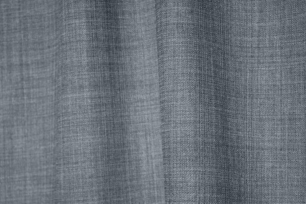 Close-up van de grijsblauwe gordijnstof uit de Florain collectie (JC2521) van Okika, met subtiel gemeleerd effect die kleurvast is