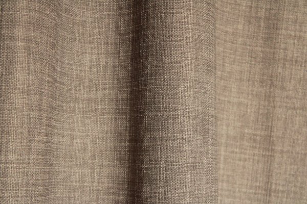 Detailfoto van de stof van grijze gordijnen uit de Florain collectie (JC2522) van Okika, met een gemeleerde stofstructuur voor extra sfeer