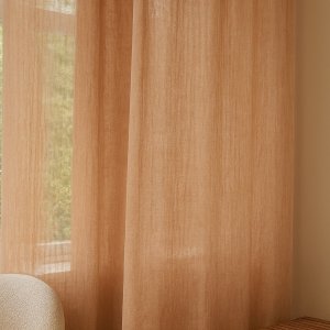 Inbetween gordijnen van 100% linnen in honingkleur, warm en sfeervol opgehangen in een natuurlijk ingerichte woonkamer