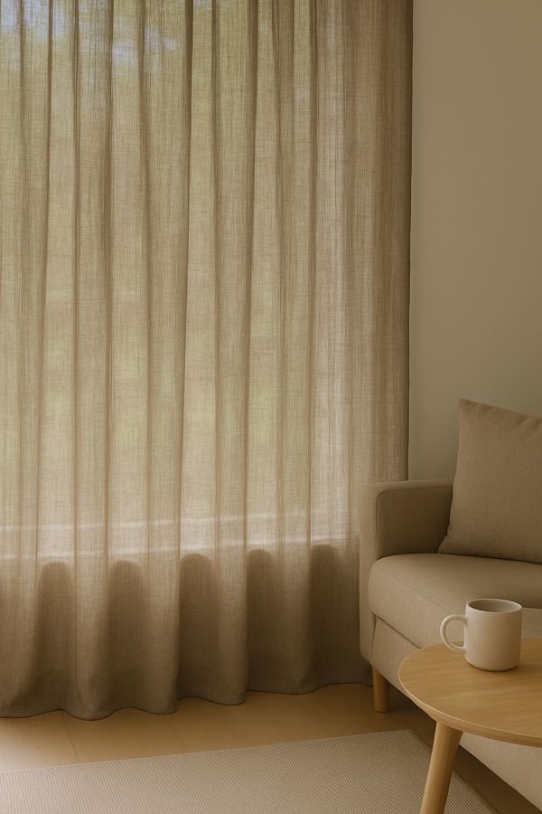 Inbetween gordijnen van 100% linnen in taupe, lichtdoorlatend opgehangen in een sfeervolle interieursetting met natuurlijke materialen.