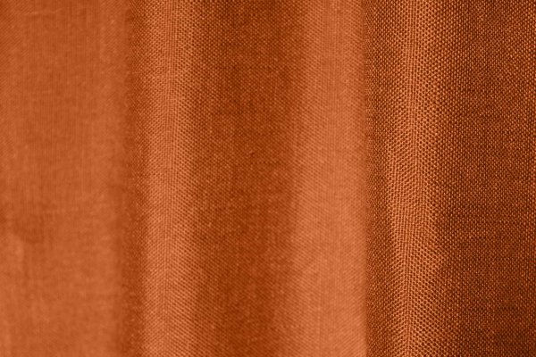 Sfeerfoto van roestkleurige inbetween gordijnen met linnen look uit de Saphira Light collectie van Okika, soepel vallend en lichtdoorlatend.